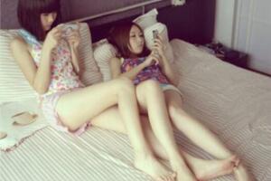 两个有大白腿的美女在床上玩手机